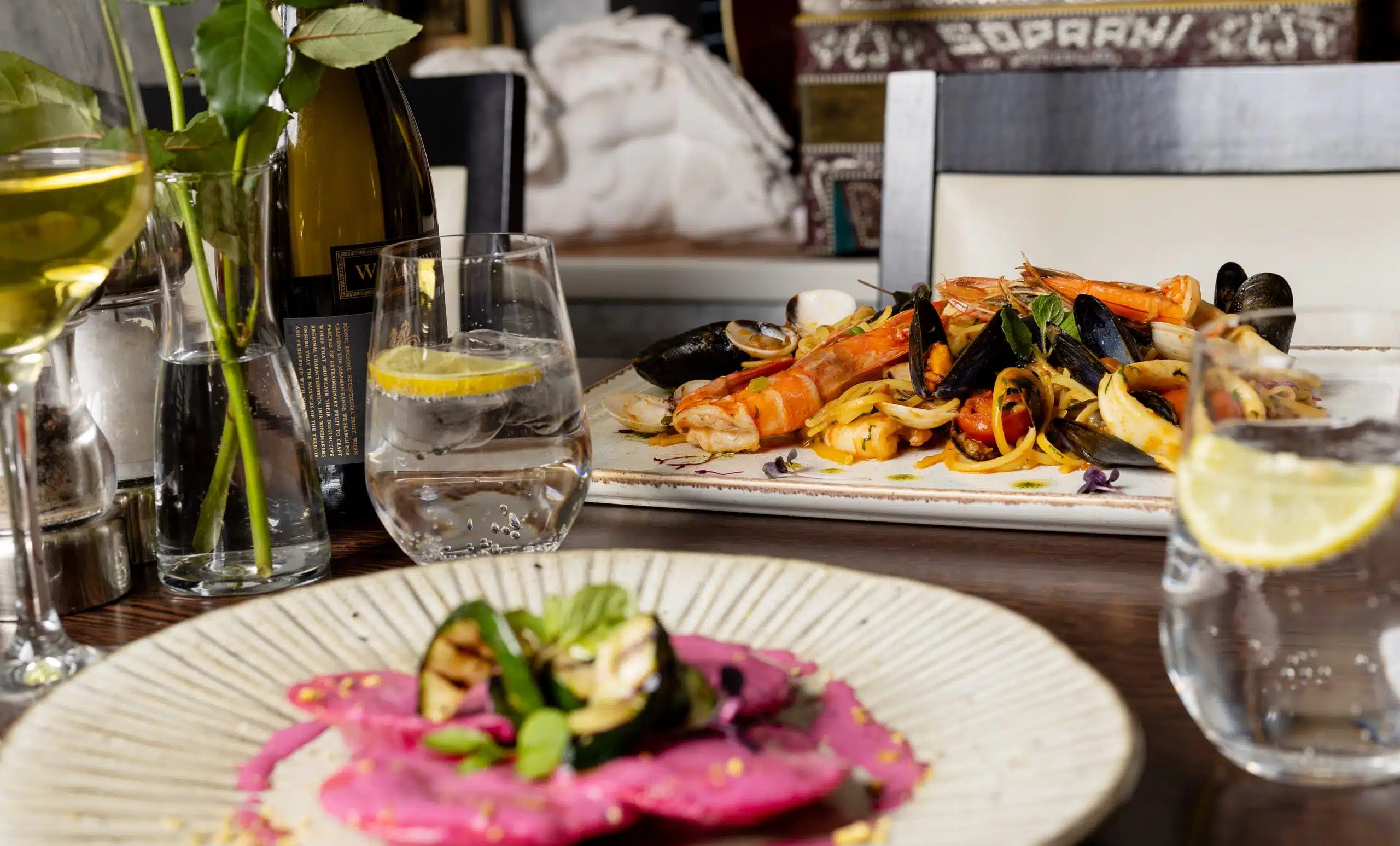 A table set with a plate of food and a glass of wine